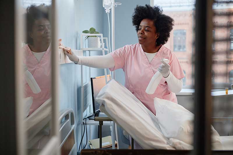 Nursing Home Aide cleaning a room.